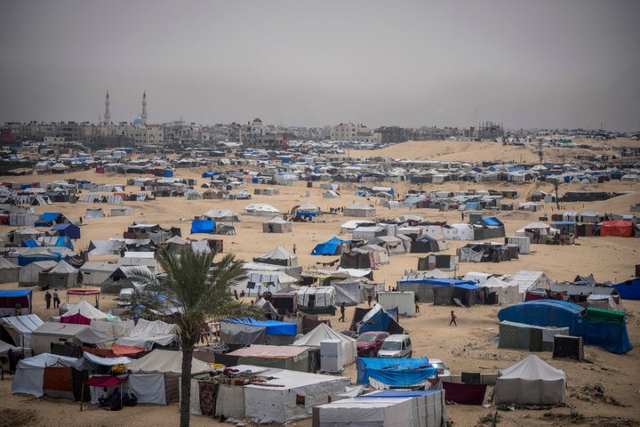 Palestinians displaced by the Israeli air-and-ground offensive on the Gaza Strip walk through a makeshift tent camp in Rafah, Gaza, on May 10.