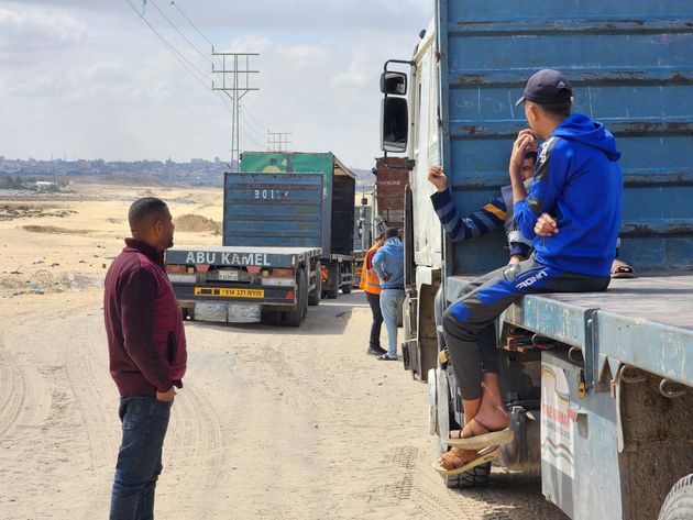 Palestinian truck drivers and United Nations vehicles wait Tuesday near the Rafah crossing on the Gaza side to cross into Egypt.