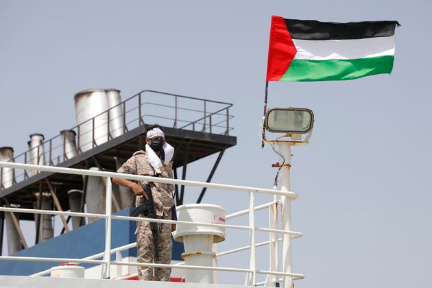 Αντάρτης Χούθι επί του ισραηλινού πλοίου Galaxy έχοντας στο πλάι του την παλαιστινιακή σημαία (12 Μαϊου 2024)