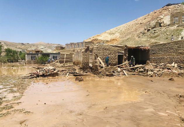 Αφγανοί άντρες μαζεύουν τα υπάρχοντά τους από το κατεστραμμένο σπίτι τους μετά από βαριές πλημμύρες στην επαρχία Γκορ στο δυτικό Αφγανιστάν το Σάββατο 18 Μαΐου 2024.