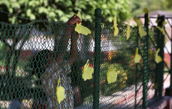 Ένα αγόρι βάζει κίτρινες χάρτινες πεταλούδες στον φράχτη του νηπιαγωγείου όπου βρισκόταν το σχολείο στο οποίο φοίτησε ο Μάρκες, Αρακατάκα, Απρίλιος 2014. (AP Photo/Ricardo Mazalan)