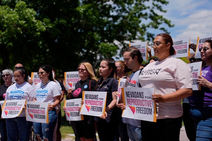 Supporters of the amendment hold up signs at a Las Vegas news conference Monday.