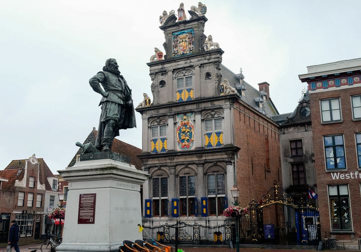 Σε αυτήν φωτογραφία, στις 11 Ιουνίου 2020, βλέπουμε ένα άγαλμα του Ολλανδού εμπόρου της Χρυσής Εποχής και βάναυσου αποικιοκράτη Jan Pieterszoon Coen, να στέκεται ψηλά πάνω από μια πλατεία στη γενέτειρά του στο Hoorn, βόρεια του Άμστερνταμ της Ολλανδίας. Ο Κοέν ήταν ηγετική φυσιογνωμία στην εμπορική δύναμη του 17ου αιώνα, την Ολλανδική Εταιρεία Ανατολικών Ινδιών, αλλά έχει μείνει στην ιστορία ως ο «χασάπης του Μπάντα», ο άνθρωπος που διέταξε μια αιματηρή σφαγή στα νησιά Μπάντα, στην Ινδονησία. (AP Photo/Michael Corder, File)
