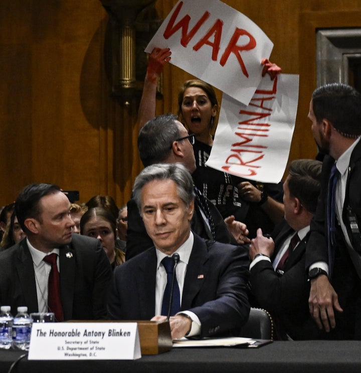 A pro-Palestinian protester carrying a banner that says "War Criminal" is removed from the room as Secretary of State Antony Blinken testifies before the Senate Foreign Relations Committee in Washington, D.C., on May 21, 2024.