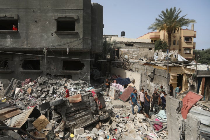 Palestinians look at the destruction after an Israeli strike on a residential building in Nuseirat Refugee Camp, Gaza Strip, Sunday, May 19, 2024. (AP Photo/Ismael Abu Dayyah)