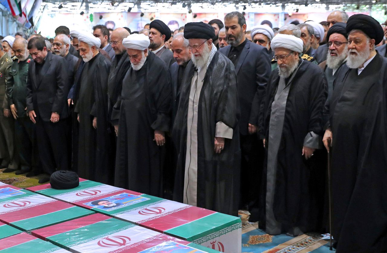 Σε αυτή τη φωτογραφία που δόθηκε στη δημοσιότητα από το γραφείο του ανώτατου ηγέτη του Ιράν, Αγιατολάχ Αλί Χαμενεΐ, στο κέντρο, φορώντας μαύρο τουρμπάνι, προσεύχεται πάνω από τα σκεπασμένα με την ιρανική σημαία φέρετρα του προέδρου της χώρας, Εμπραχίμ Ραΐσι, και των συνταξιδιωτών του, που σκοτώθηκαν σε συντριβή ελικοπτέρου την Κυριακή σε ορεινή περιοχή στα βορειοδυτικά της χώρας, στην πανεπιστημιούπολη του Πανεπιστημίου της Τεχεράνης, κατά τη διάρκεια κηδείας στην Τεχεράνη, Ιράν, Τετάρτη 22 Μαΐου 2024.