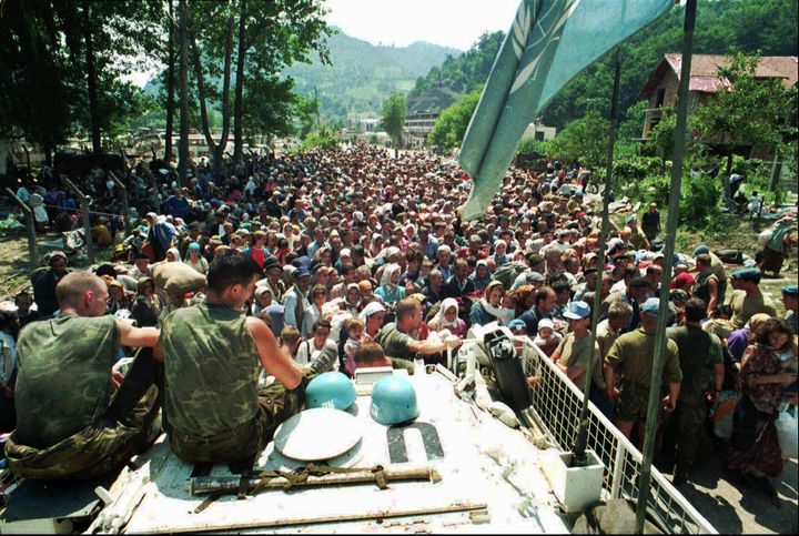 ΑΡΧΕΙΟ - Αυτή η φωτογραφία της 13ης Ιουλίου 1995 δείχνει Ολλανδούς στρατιώτες της ειρηνευτικής δύναμης του ΟΗΕ να κάθονται πάνω σε ένα θωρακισμένο όχημα, καθώς Μουσουλμάνοι πρόσφυγες από τη Σρεμπρένιτσα, στην ανατολική Βοσνία, συγκεντρώνονται στο χωριό Ποτοτσάρι, περίπου 5 χλμ. βόρεια της Σρεμπρένιτσα. Το κατηγορητήριο εναντίον του Ράτκο Μλάντιτς, ο οποίος δικάστηκε την Τετάρτη 16 Μαΐου 2012 στο δικαστήριο του ΟΗΕ για εγκλήματα πολέμου στη Χάγη, στην Ολλανδία, θεωρεί τον πρώην Σερβοβόσνιο διοικητή του στρατού "ατομικά ποινικά υπεύθυνο για σχεδιασμό, υποκίνηση, διαταγή και/ή βοήθεια και συνέργεια στα εγκλήματα που αναφέρονται σε αυτό το κατηγορητήριο». Ο Μλάντιτς κατηγορείται για 11 κατηγορίες για γενοκτονία, εγκλήματα κατά της ανθρωπότητας και παραβιάσεις των νόμων και των εθίμων του πολέμου. Μεταξύ Ιουλίου 1995 και Νοεμβρίου 1995, ο Μλάντιτς συμμετείχε στην «εξάλειψη» των Βόσνιων Μουσουλμάνων στον ανατολικό θύλακα της Σρεμπρένιτσα σκοτώνοντας άνδρες και αγόρια και απομακρύνοντας βίαια τις γυναίκες, τα μικρά παιδιά και μερικούς ηλικιωμένους άνδρες. Περίπου 7.000 άνθρωποι σκοτώθηκαν, που είναι και η μεγαλύτερη σφαγή στην Ευρώπη από τον Β' Παγκόσμιο Πόλεμο. (AP Photo)