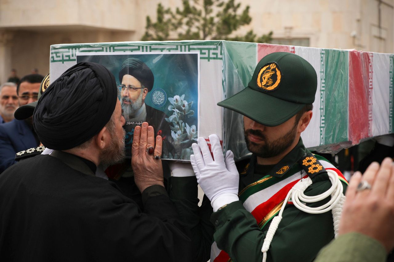 Σε αυτή τη φωτογραφία που δημοσιεύεται από το Γραφείο της Ιρανικής Προεδρίας, ένας κληρικός φιλάει το φέρετρο του προέδρου Εμπραχίμ Ραΐσι, ντυμένο με τη σημαία, κατά τη διάρκεια της τελετής κηδείας του ίδιου και των συντρόφων του που σκοτώθηκαν σε συντριβή ελικοπτέρου την Κυριακή σε ορεινή περιοχή στα βορειοδυτικά της χώρας, στην πόλη Ταμπρίζ του Ιράν, Τρίτη 21 Μαΐου 2024. (Γραφείο Ιρανικής Προεδρίας μέσω AP)