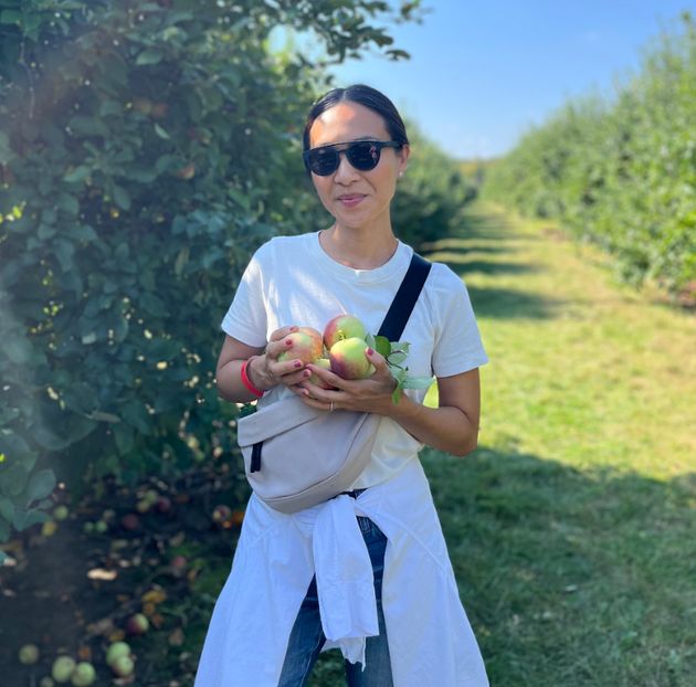 The author is pictured while apple picking in Michigan in 2023.