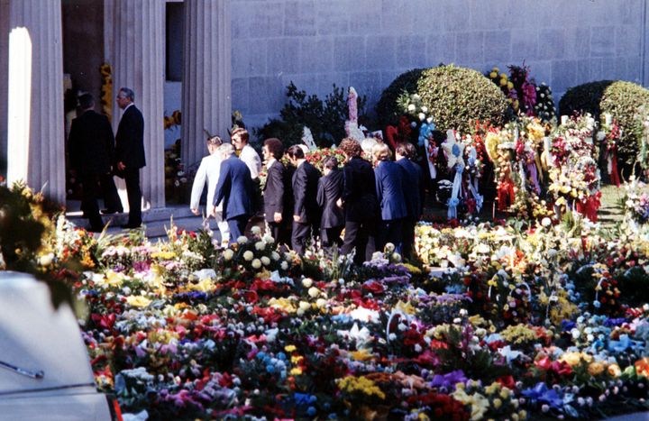 Σε αυτή τη φωτογραφία αρχείου της 18ης Αυγούστου 1977, κουβαλητές μεταφέρουν το καλυμμένο με λουλούδια φέρετρο του Elvis Presley στο μαυσωλείο Forest Hills Cemeteries στο Μέμφις του Τενεσί. Αφού ένας κλέφτης προσπάθησε να αρπάξει τη σορό του, τα λείψανα τόσο του Elvis όσο και της μητέρας του μεταφέρθηκαν σε έναν κήπο στην Graceland.