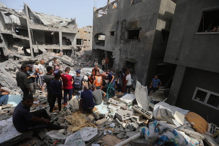 Palestinians look at the destruction after an Israeli strike on a residential building in Nuseirat Refugee Camp, Gaza Strip, Sunday, May 19, 2024. (AP Photo/Ismael Abu Dayyah)