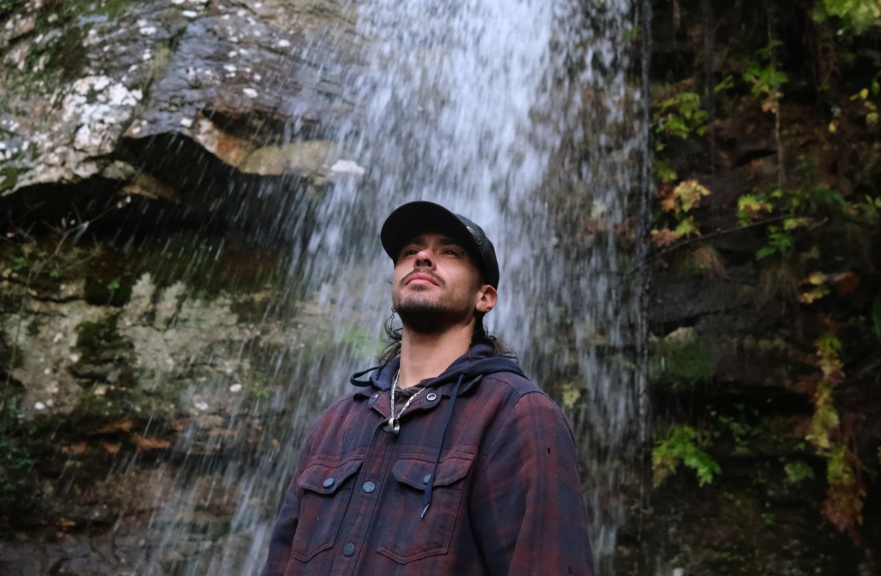Aurik Antunes, 33, a Portuguese artist and barber living in Covas do Barroso, Portugal, visits a waterfall, one of the natural waterways local opponents of the lithium project fear will be threatened by the mining.