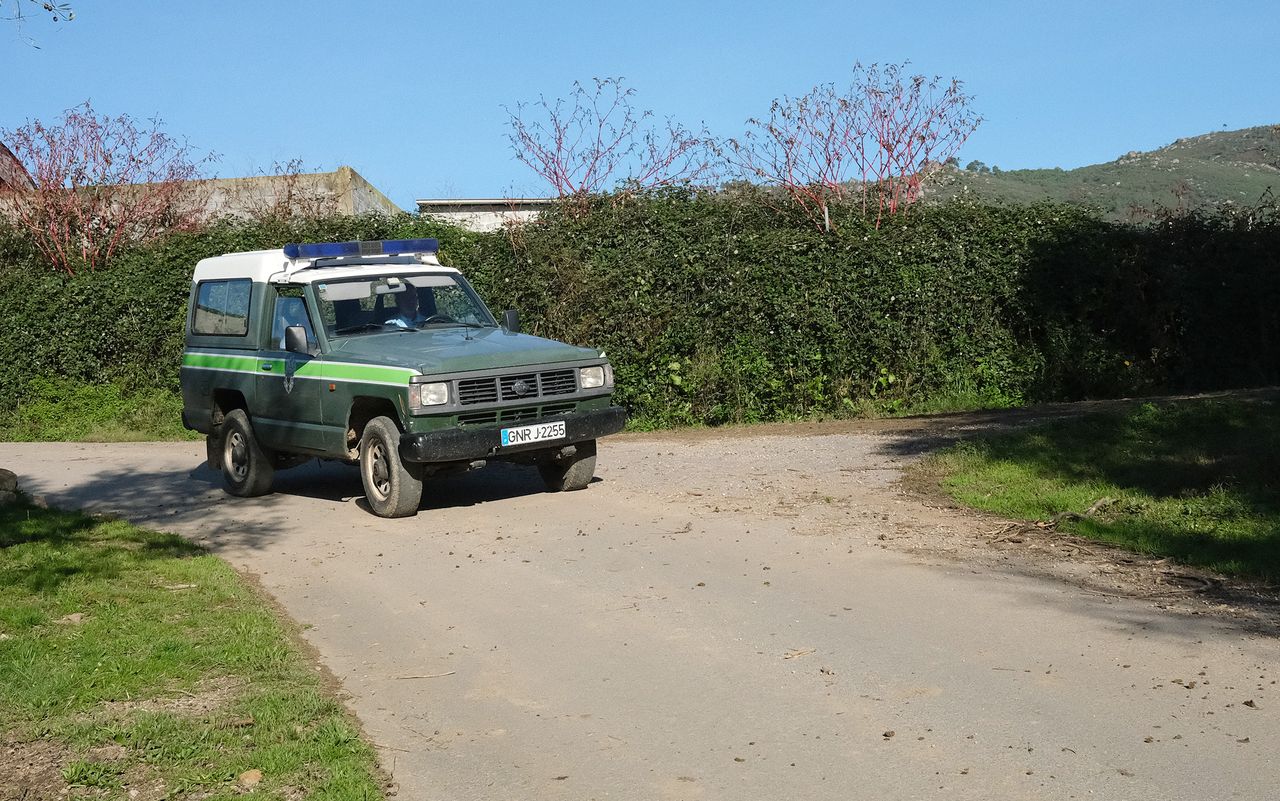 A national police vehicle drives past Aida Fernandes' farm on patrol. The police presence has increased as opposition to mining has become more visible.