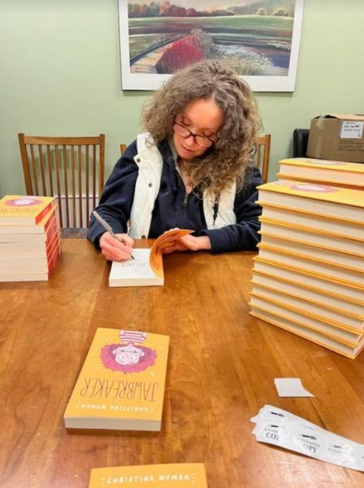 The author signing copies of her debut Middle Grade novel, "Jawbreaker," at her local bookstore in the fall of 2023.