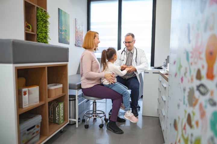 Girl being examined by male pediatrician in the office.