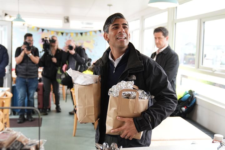 Rishi Sunak speaks with a cafe worker as he picks up breakfast for the media at a cafe in Cornwall this morning.