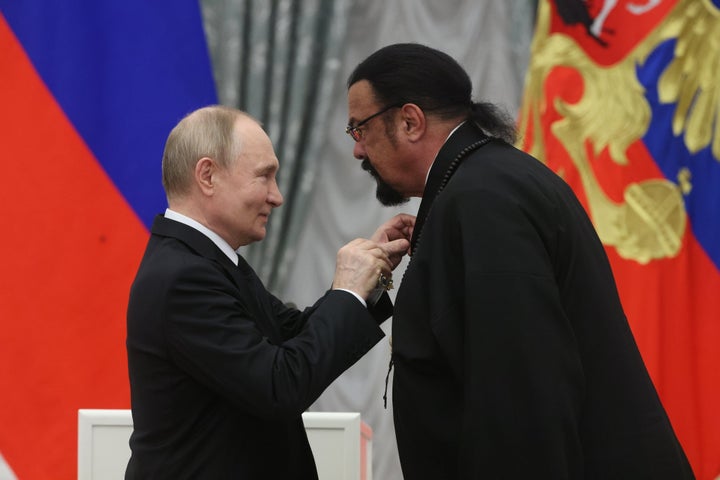 Russian President Vladimir Putin, left, gives the Order of Friendship to Steven Seagal during a May 30, 2024, ceremony at the Kremlin. While accepting the honor, Seagal aired some bizarre accusations against Russia's military opponent, Ukraine.