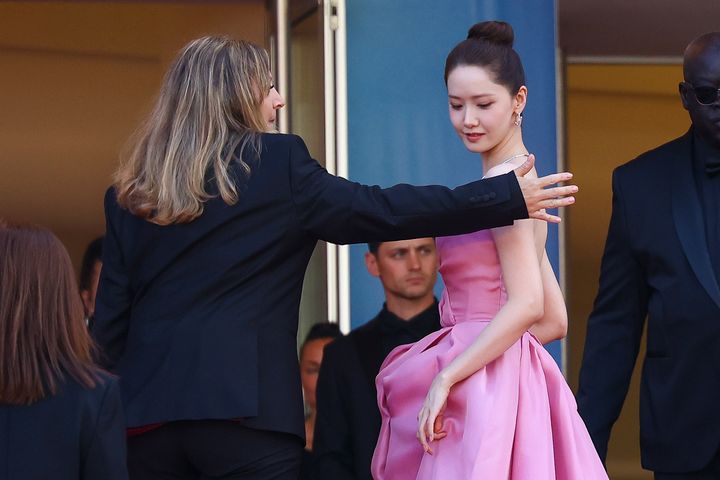 South Korean singer and actor Yoona appears dismayed that the staffer is touching her.