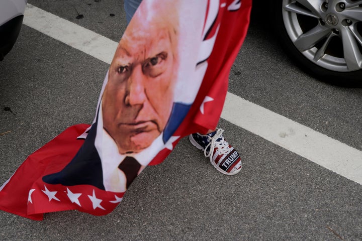 Trump’s Been Convicted. Right here Are 8 Urgent Questions About What Occurs Subsequent. 1 A flag featuring a portrait of Donald Trump is carried Thursday amid a group of Trump supporters near Mar-a-Lago in Palm Beach, Florida.