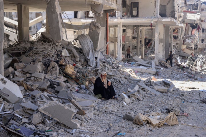 A Palestinian woman talks on her phone as she sits in the rubble of her home in the wake of an Israeli air and ground offensive in Jebaliya, northern Gaza Strip after Israeli forces withdrew from the area, Friday, May 31, 2024. (AP Photo/Enas Rami)