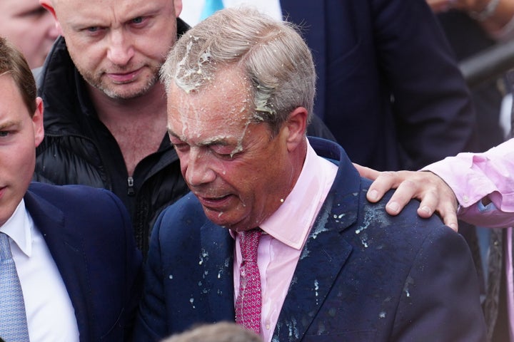 Nigel Farage reacts after a woman threw a drink over him.