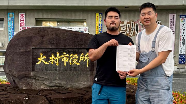 大村市役所で事実婚と同様の住民票を交付された松浦慶太さん（右）と藤山裕太郎さん