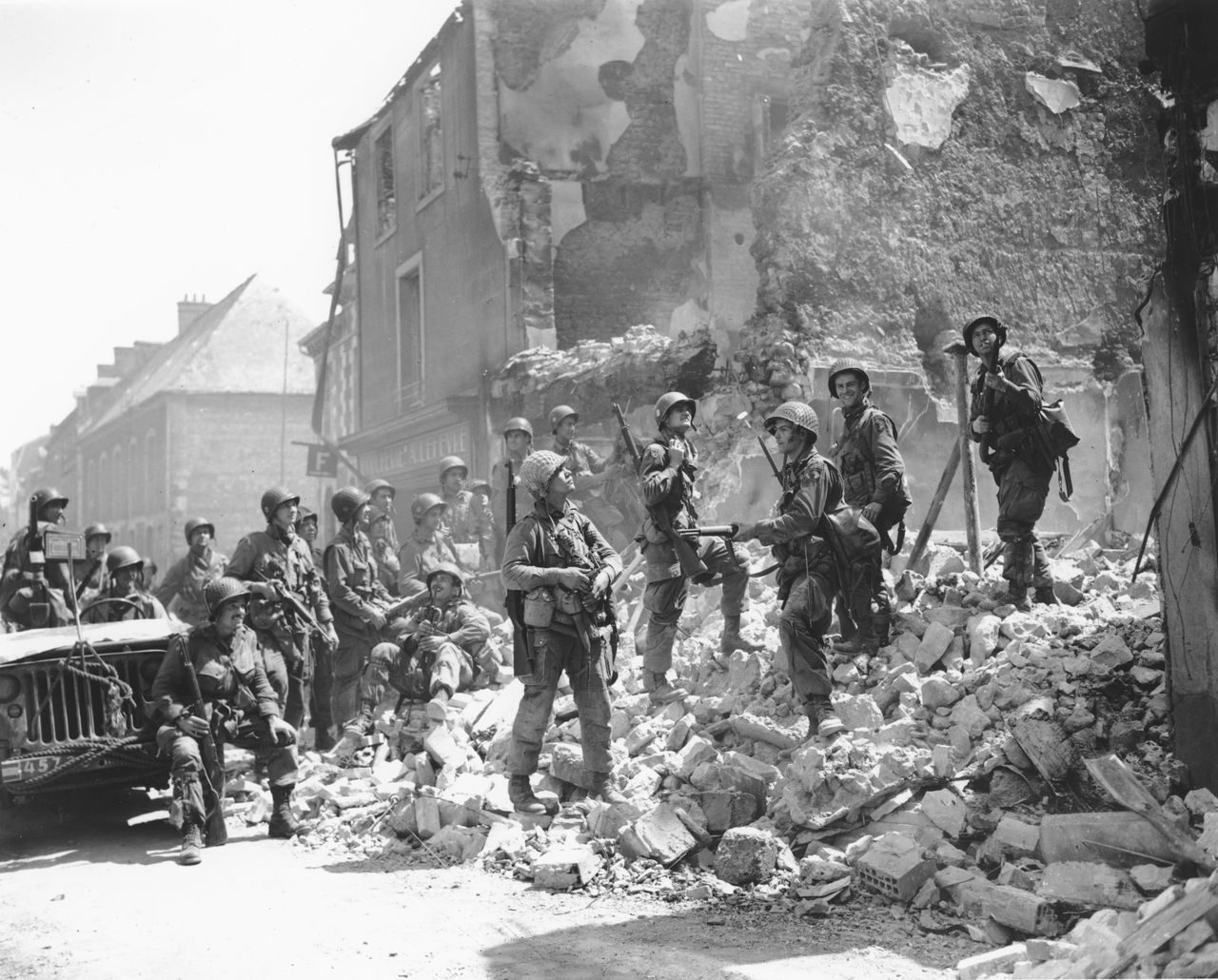 FILE - U.S. soldiers stand on the remains of a house as they inspect damage in Carentan, in the Normandy region of France, June 15, 1944. The 80th anniversary this week of D-Day is a mixed bag of emotions for French survivors of the 391 / 5.000 ΑΡΧΕΙΟ - Αμερικανοί στρατιώτες στέκονται στα ερείπια ενός σπιτιού καθώς επιθεωρούν τις ζημιές στο Carentan, στην περιοχή της Νορμανδίας της Γαλλίας, 15 Ιουνίου 1944. (AP Photo/Peter Carroll, File)