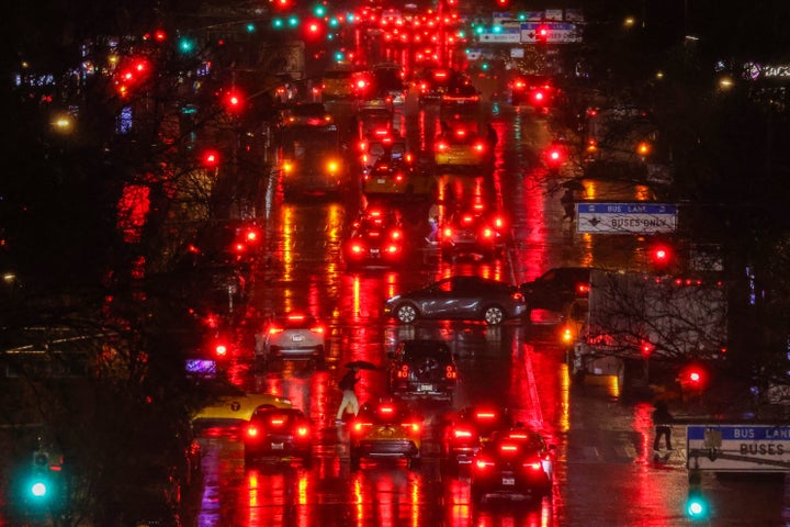 Pedestrians and cars move along First Avenue in the Manhattan borough of New York, in the pouring rain, on Feb. 27.