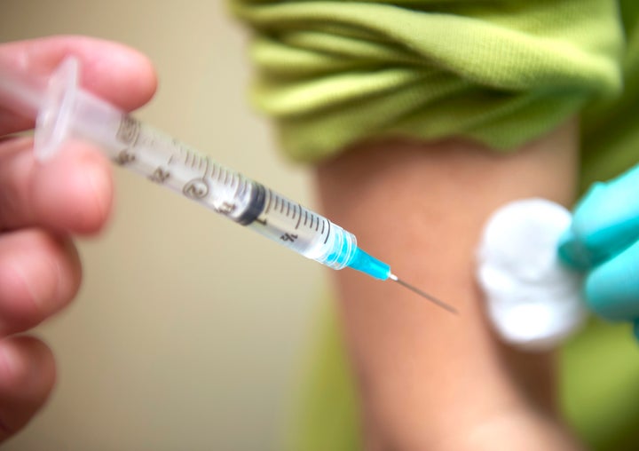 Syringe being used to vaccinate patient