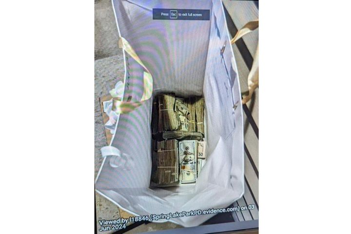 This photo supplied by the U.S. Attorney's Office for Minnesota shows cash from a bag that was left at the home of a juror in a massive fraud case, June 2, 2024, outside Minneapolis.