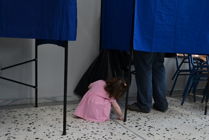 Στιγμιότυπο από Εκλογικό Κέντρο στην Ελλάδα. Μια μικρούλα έχει ζωηρή περιέργεια για την διαδικασία και αν και είναι αρκετά νεαρή για να ψηφίσει, συμμετέχει κι εκείνη με τον δικό της τρόπο.
