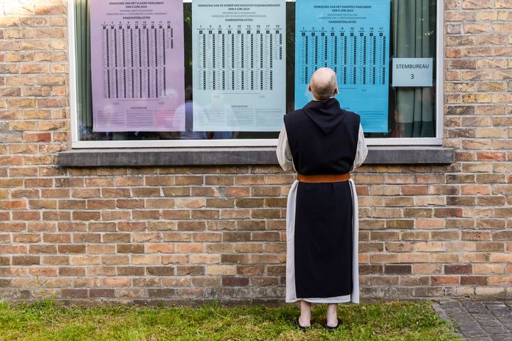 Μοναχός στο Βέλγιο κοιτά τους εκλογικούς καταλόγους πριν ρίξει την ψήφο του 