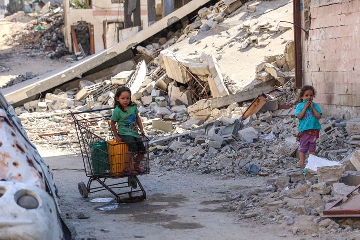 戦闘で破壊されたガザ市で金属製のカートに座る子ども。ガザ市では深刻な水不足が起きている（2024年6月10日）