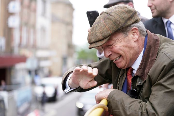 Reform UK leader Nigel Farage reacts after something is thrown towards him on a campaign bus in Barnsley, England.