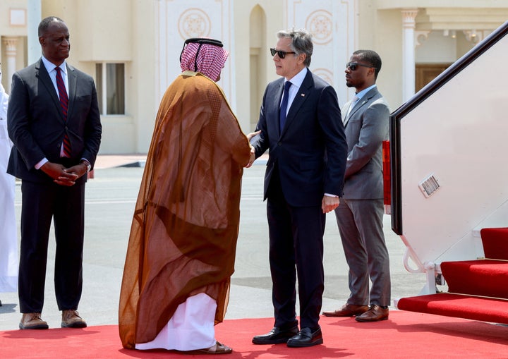 U.S. Secretary of State Antony Blinken, right, is greeted by a Qatari official upon his arrival in Doha, on June 12, 2024.