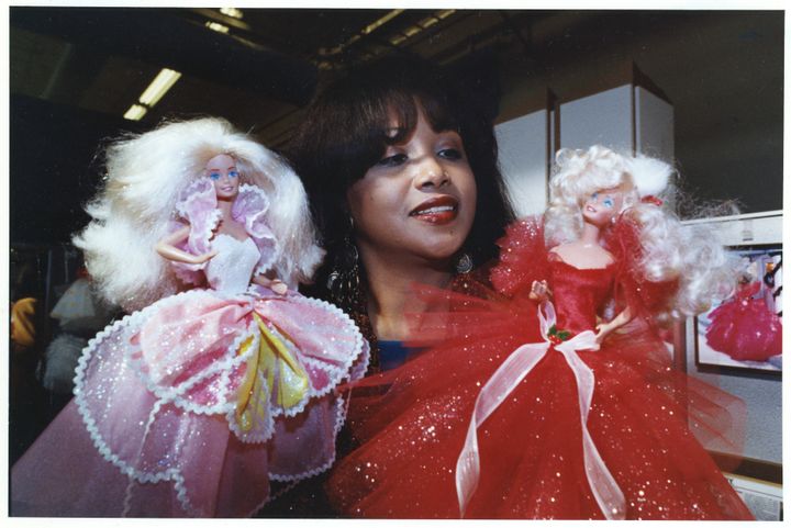 Principal fashion designer Kitty Black Perkins shows off two of her creations for Barbie dolls at the Mattel offices in 1991.
