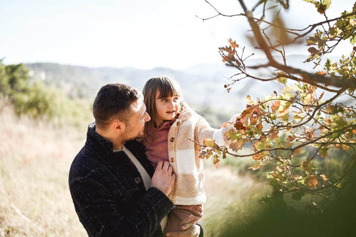 young father with preschool daughter in forest.