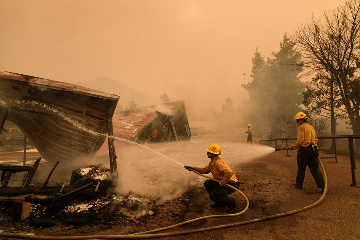 Firefighters hose down a structure at the Los Padres Forest Station while fighting the Post Fire on Saturday, June 15, 2024, in Lebec, Calif. (AP Photo/Marcio Jose Sanchez)