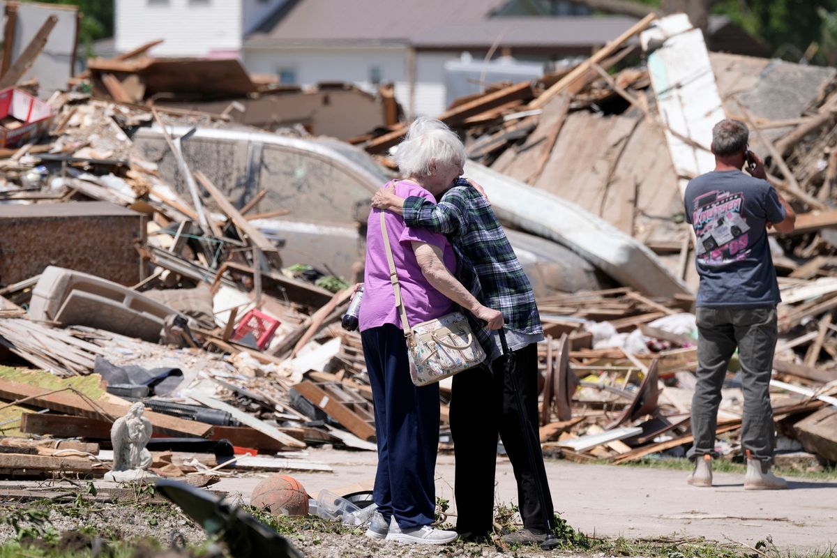 Joan Mitchell, left, gets a hug from her neighbor Edith Schaecher in front of their tornado damaged homes, Thursday, May 23, 2024, in Greenfield, Iowa. (AP Photo/Charlie Neibergall)