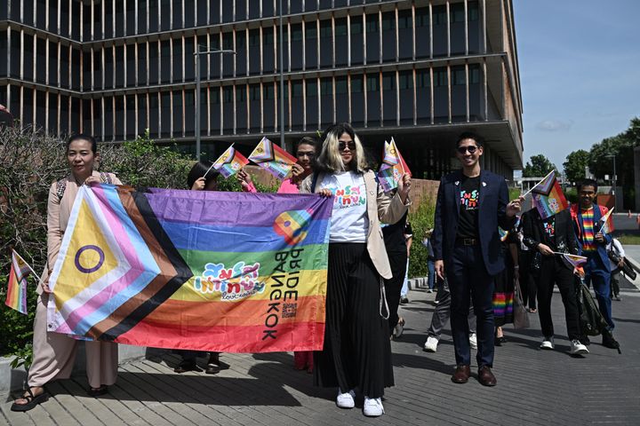 結婚平等法案の上院での投票を前に、首都バンコクの国会周辺でレインボーやトランスカラーのフラッグをかざす人々（2024年6月18日）