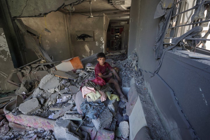 A Palestinian boy salvages items from a damaged apartment on June 18 following overnight Israeli strikes in al-Bureij refugee camp in the central Gaza Strip.