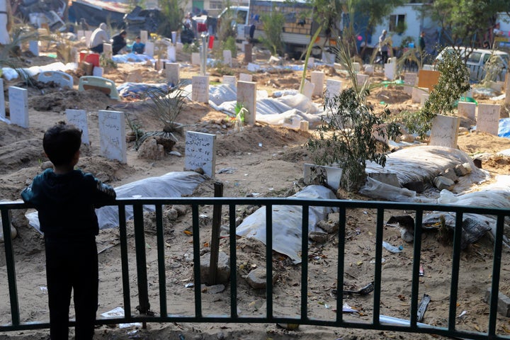 A Palestinian child looks Dec. 31 at the graves of people killed in the Israeli bombardment of the Gaza Strip and buried inside the Shifa Hospital grounds in Gaza City.