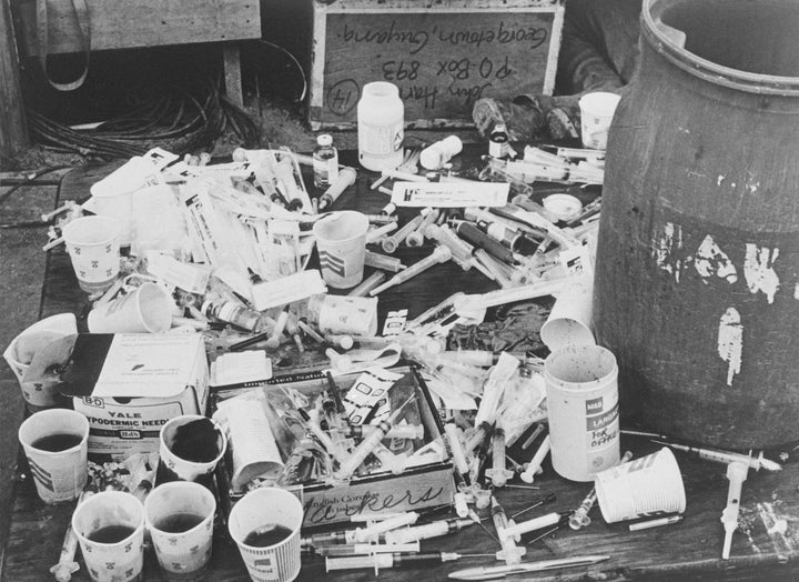 A table piled with cups of fruit punch and hypodermic syringes containing cyanide that were used to kill members of the Peoples Temple at Jonestown.