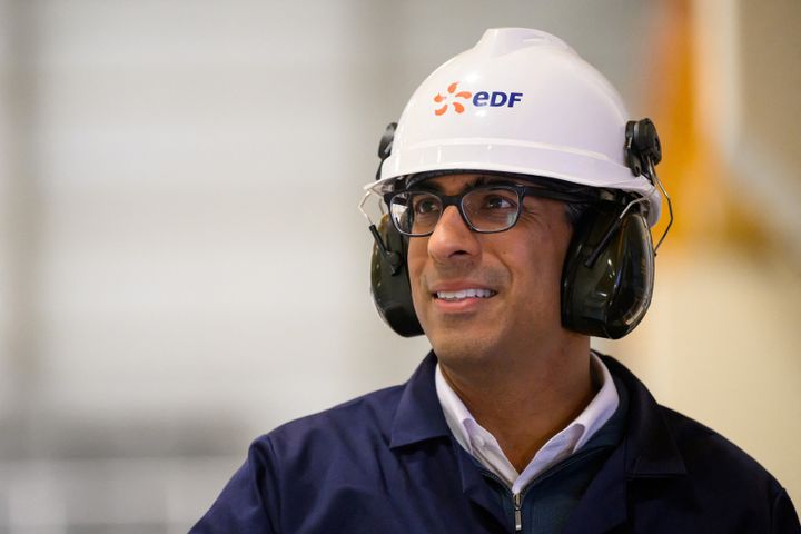 Sunak reacts as he visits the Sizewell B nuclear power facility, wearing a hard hat.