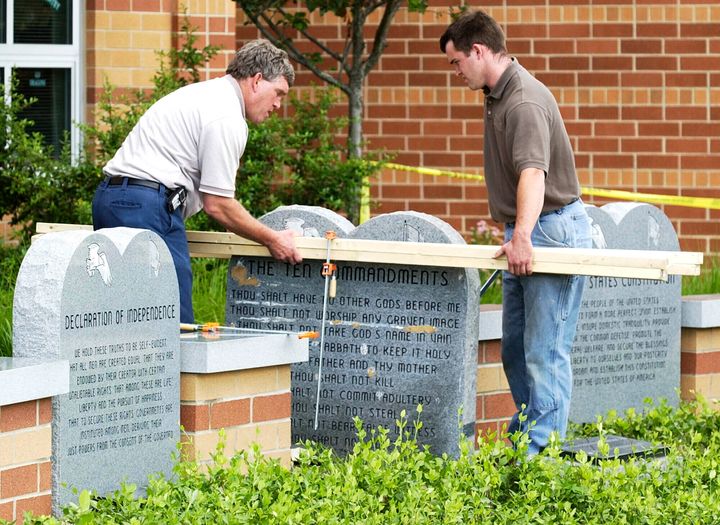 Workers remove a monument bearing the Ten Commandments outside West Union High School, Monday, June 9, 2003, in West Union, Ohio. Louisiana became the first state to require that the Ten Commandments be displayed in every public school classroom — in another expansion of religion into day to day life by a Republican-dominated legislature.