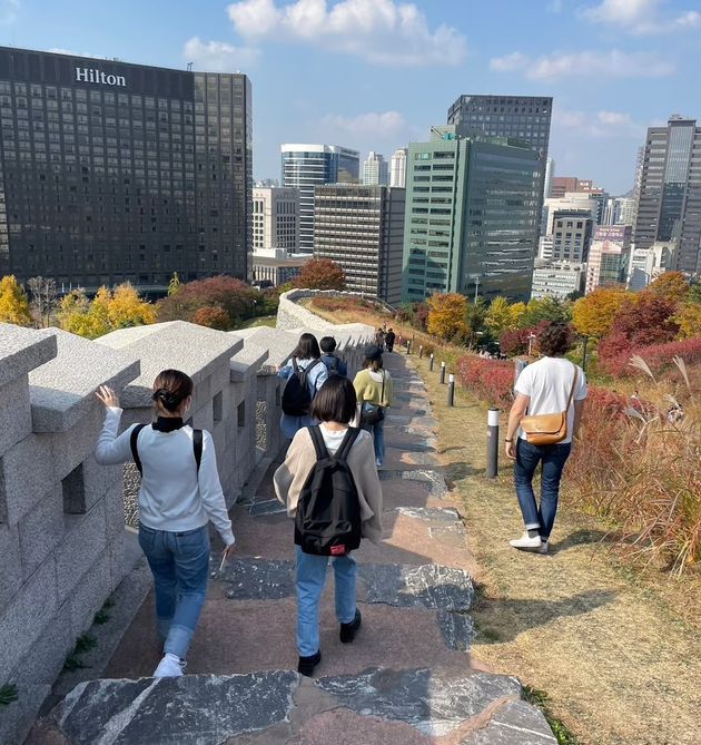 タプサで南山近くにある復元された朝鮮王朝時代の城壁を歩く学生たち（2022年10月28日撮影）
