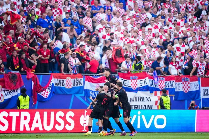 Οι παίκτες της Αλβανίας πανηγυρίζουν αφού ο συμπαίκτης τους Κλάους Γκιάσουλα, επάνω, πέτυχε το δεύτερο γκολ της ομάδας τους κατά τη διάρκεια του αγώνα του ομίλου Β μεταξύ της Κροατίας και της Αλβανίας στο τουρνουά ποδοσφαίρου Euro 2024 στο Αμβούργο της Γερμανίας, Τετάρτη 19 Ιουνίου 2024. Ο αγώνας έληξε ισόπαλος 2-2. (AP Photo/Ebrahim Noroozi)