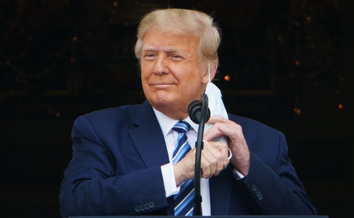 President Donald Trump takes his mask off before speaking at a rally at the White House on Oct. 10, 2020.