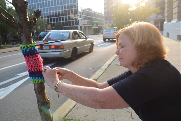 Μια κυρία επιδίδεται στο λεγόμενο yarn bombing, «ντύνοντας» ένα δέντρο με νήματα στην οδό Ουάσινγκτον της Νέας Υόρκης.