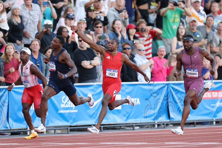 Fred Kerley, Noah Lyles and Kenny Bednarek react while crossing the finish line in the men's 100 meter final.